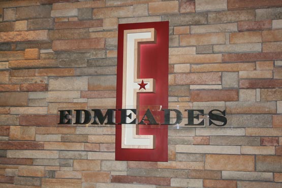 Carved maple E is back lit using a halo effect, and mounted on a rusty red metal panel.  The lettering is 3/4" 

plex with patinaed copper faces, and mounted on a "curved" clear plex panel