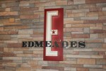 Carved maple E is back lit using a halo effect, and mounted on a rusty red metal panel.  The lettering is 3/4" 

plex with patinaed copper faces, and mounted on a "curved" clear plex panel