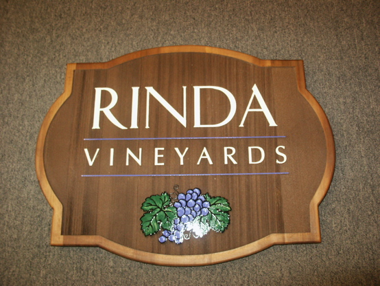 Sandblasted cedar with verticle grain and a light stain.  The grape graphic is design by us and hand lettered