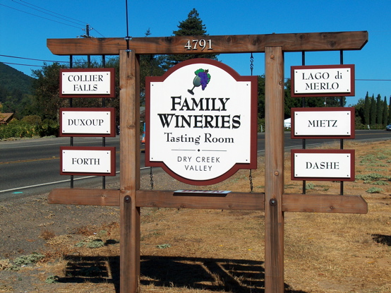 Matted wood signs on natural redwood structure.  We mounted the winery names on the sides because the County gave us a strict height restriction. It is a unusual design idea but it allowed us to comply